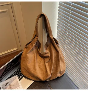 Close-up of a large brown suede hobo tote bag featuring a textured matte finish and soft drape