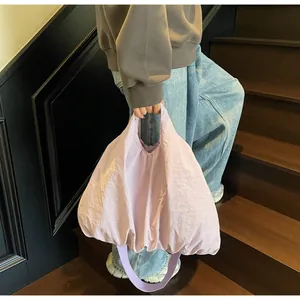 Close-up of light purple puffy cloud tote bag with pleated texture and wide strap