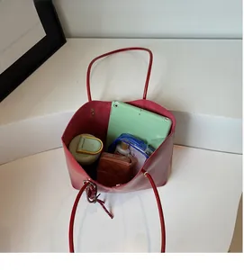 Vista dall'alto dello spazioso interno della borsa tote rossa con tablet e accessori