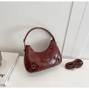 Detail of wine red hobo bag with glossy wrinkled leather and silver hardware