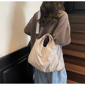 Close-up of beige canvas tote bag with adjustable strap on a minimalist wooden staircase