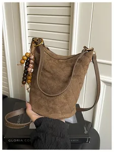 Gesteppte braune Beuteltasche aus Wildleder mit Perlenquaste und Golddetails