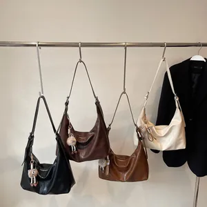 Minimalist large leather tote bags in four neutral colors hanging on a metal rack