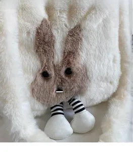 Detailed view of white plush tote bag featuring a cute bunny character with striped legs