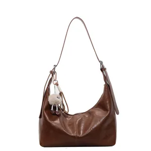 Brown leather moon shoulder bag with cute plush pendant and adjustable strap