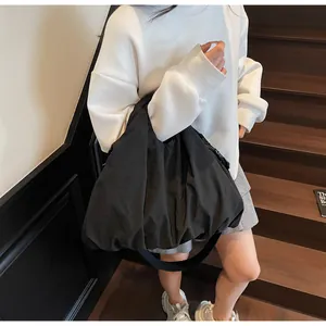 Close-up of black oversized cloud-style shoulder bag with puffy pleated fabric texture