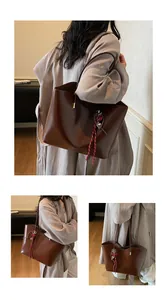 Dettaglio di una borsa tote in pelle marrone cerata con nappa decorativa e spalline fini