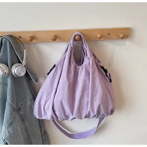 Detail of light purple canvas bag with side adjustable buckle and large capacity texture
