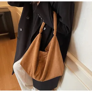 Detail view of large brown suede shoulder bag with natural drape and elegant texture
