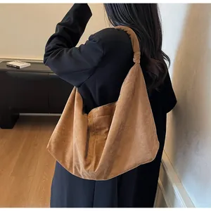 Detail view of brown faux suede hobo bag with knotted shoulder strap and slouchy design