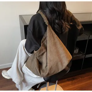 Detail of soft dark brown suede hobo bag with unique knotted shoulder strap