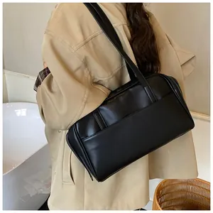 Detail einer minimalistischen schwarzen Leder-Einkaufstasche getragen von einem Modell