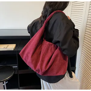 Detail of burgundy suede hobo bag with unique knotted strap and slouchy design