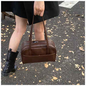 Details der dunkelbraunen Leder-Shopper-Tasche mit Reißverschluss vor Herbstkulisse