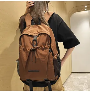 Detail eines großen braunen Nylon-Rucksacks mit Kordelzug und seitlicher Netz-Tasche