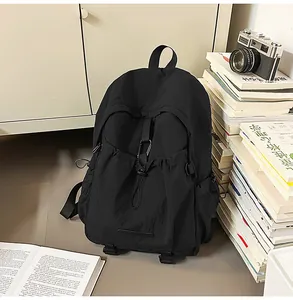 Detail eines großen schwarzen Nylon-Rucksacks mit Kordelzugtasche und seitlicher Netztasche