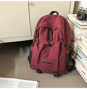 Detail eines burgunderroten, wasserfesten Nylon-Rucksacks mit Kordelzugtasche und Schnallen