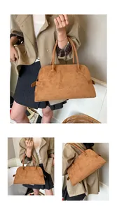 Detail der braunen Vintage-Einkaufstasche mit Doppelgriffen und Schnallendetails aus Wildleder