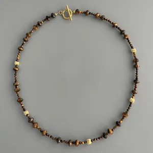 Vue détaillée de perles d'oeil de tigre avec des accents dorés et fermoir à bascule