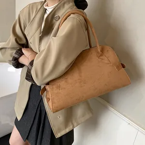 Große braune Shopper-Tasche aus Wildlederimitat im Retro-Stil an einem Model