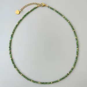 Dettaglio collana con perline verdi da 2mm, ciondolo a cuore dorato e catenella esterna