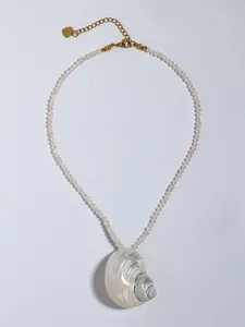 Detailopname van een parelketting met een natuurlijke schelphanger en gouden hartje