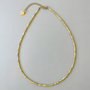 Dettaglio della collana di perline di cristallo giallo con pendente a cuore d'oro