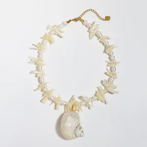 Detailweergave van een schelpenketting met natuurlijke parels en grote conch hanger
