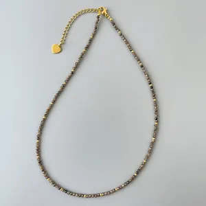 Dettaglio della collana di perle di cristallo da 2mm con chiusura dorata 18k e ciondolo a cuore