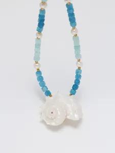Macro detail van natuurlijke schelphanger met blauwe kralen en zoetwaterparels ketting