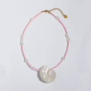 Macro detail van parelketting met een grote schelphanger en goudkleurige sluiting