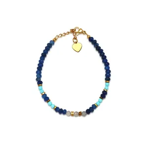 Lapis lazuli beaded bracelet with turquoise accents and gold heart charm on white background