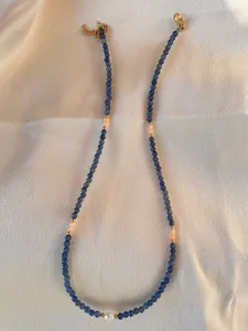 Detail of colorful gemstone beaded necklace with white pearl and 18k gold plated clasp