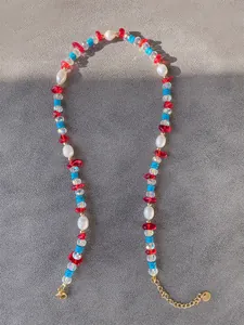 Dettaglio della collana di perline colorate con perle, pietre turchesi e chiusura oro