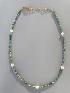 Detail of beaded necklace with green gemstones, white pearls and 18k gold plated clasp