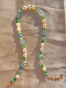 Dettaglio della collana bohémien con pietre colorate, perle e chiusura a moschettone oro
