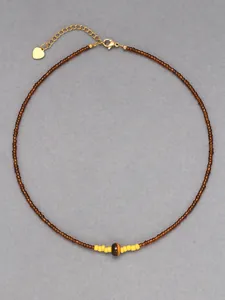 Détail du collier de perles œil de tigre avec pendentif cœur doré et fermoir homard