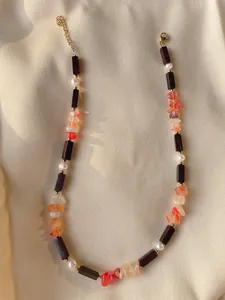 Dettaglio di collana bohémien con scaglie d'agata, perle e grani in legno scuro