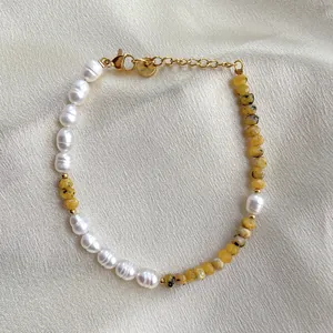 Detail of 18K gold plated bracelet featuring half pearls and yellow natural stone beads