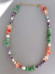 Detail of beaded necklace with green stones, pearls, and gold-plated adjustable chain