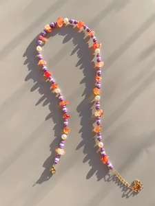 Dettaglio della collana bohémien colorata con pietre irregolari e chiusura dorata