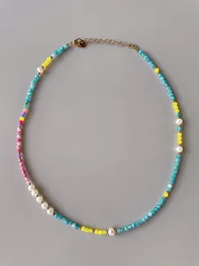 Detail of colorful faceted beads and irregular pearls on handmade gold plated necklace