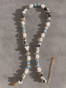 Dettaglio della collana boho con pietre irregolari, perle e chiusura a moschettone dorata