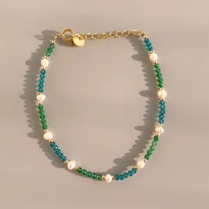 Macro detail of natural stone beaded bracelet with gold chain and freshwater pearl