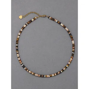 Collier de perles vintage avec œil de tigre et breloque cœur sur fond gris