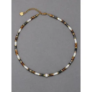 Collier rétro en perles d'œil de tigre avec pendentif cœur doré sur fond gris