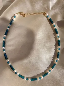 Detail of colorful gemstone beaded necklace with 18k gold lobster clasp on silk