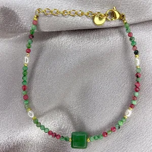 Detail of 18K gold-plated bracelet with colorful beads, pearls and green stone