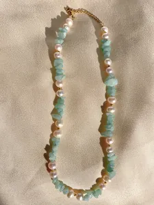 Dettaglio di perle d'acqua dolce e pietre verdi su una collana bohémien di perline