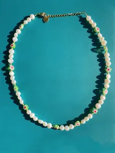 Détail du collier de perles d'eau douce avec perles en verre et breloque cœur en or 18k